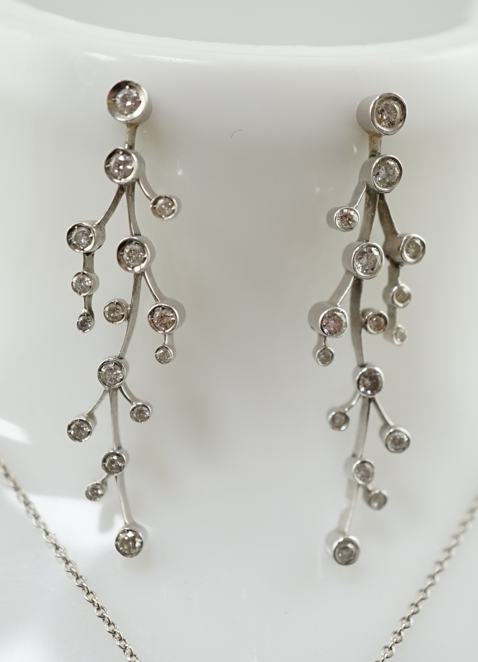 A modern 18ct white gold and diamond cluster set drop pendant on chain, together with a pair of matching drop earrings